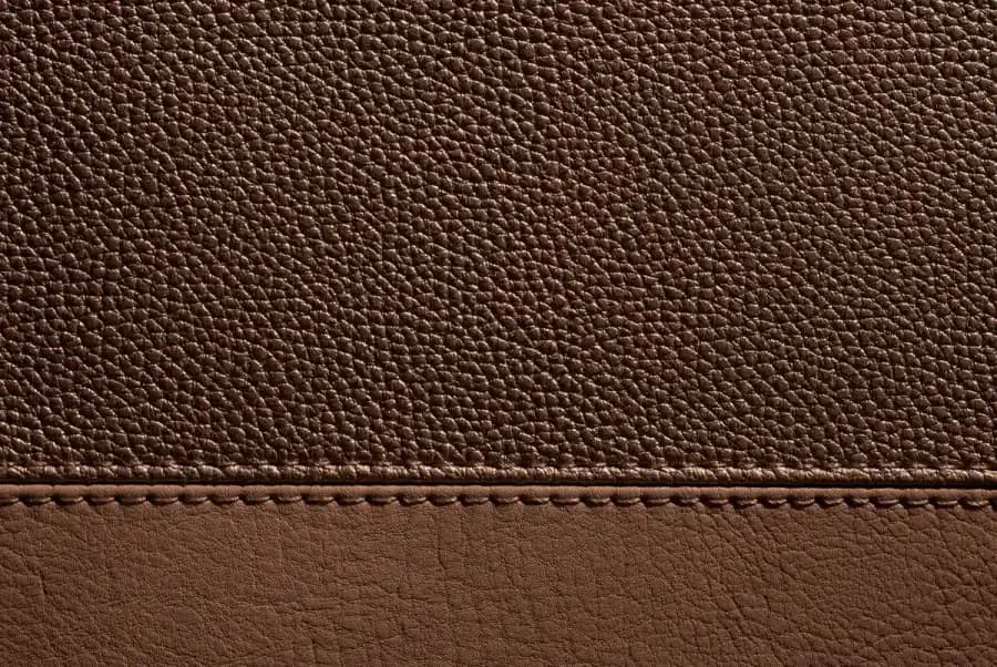 Close detail of stitched brown leather, showing grain and seam
